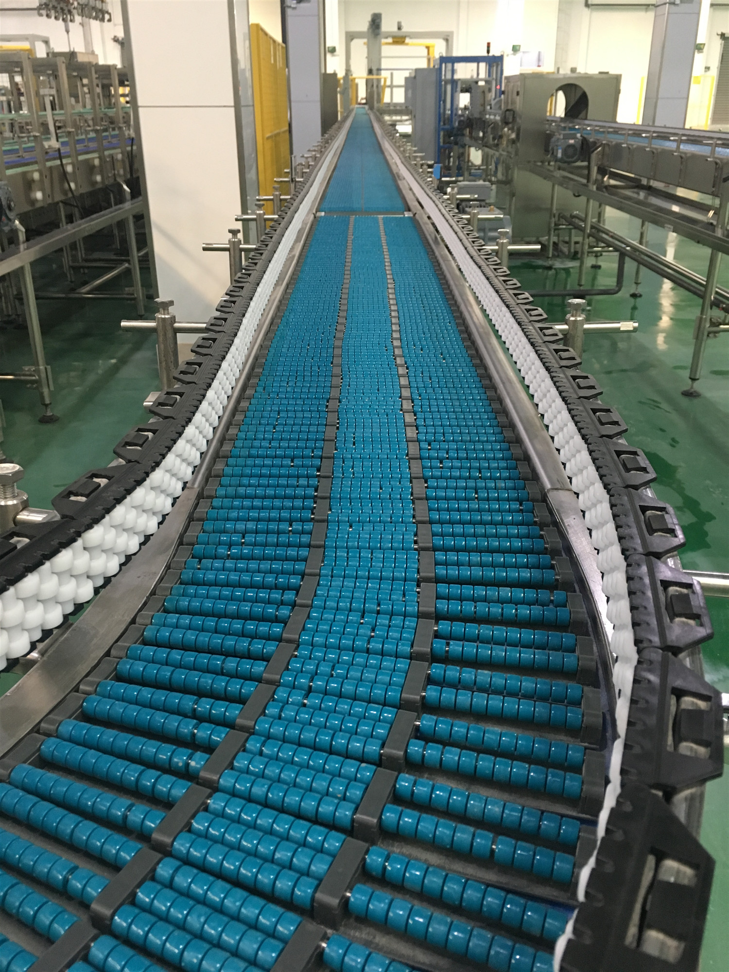 输送系统     我们可以将两条滚珠链板输送机的头尾部做成重叠式的